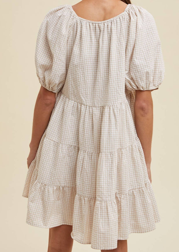 Checkered dress with puff sleeves on a beige background